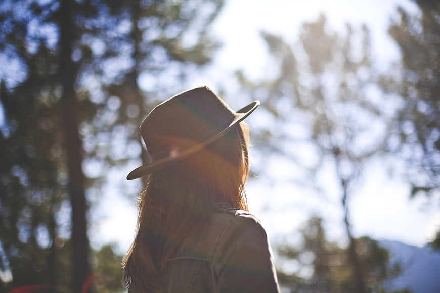 Woman in Fedora Hat Looking at Nature with Sun Flare