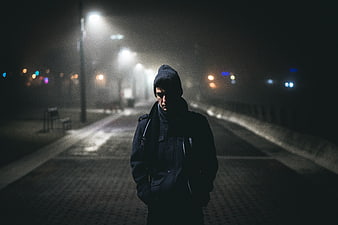 Lonely man walking alone on foggy street at night