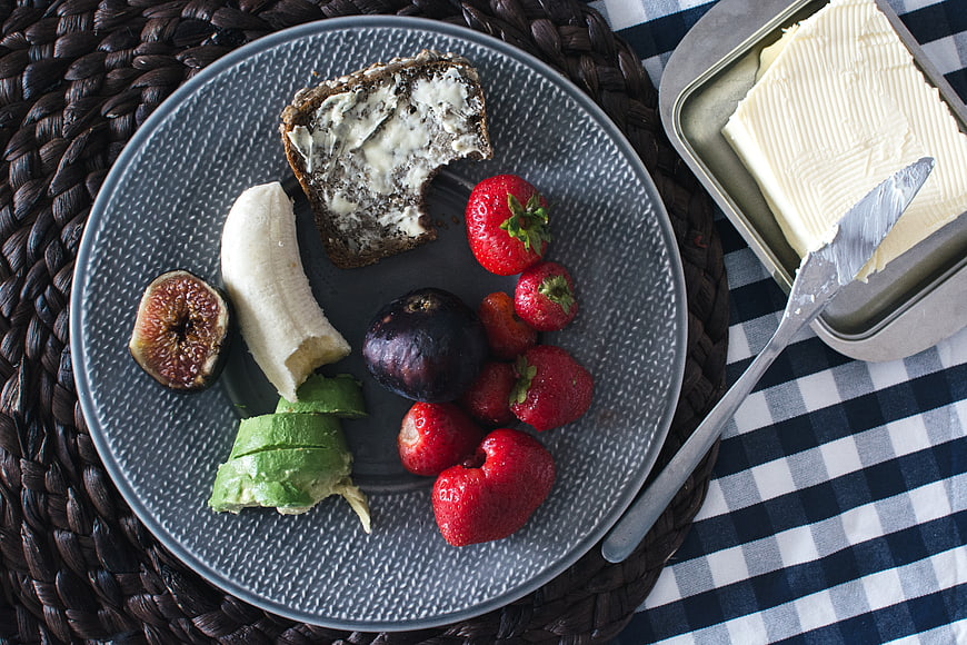 Top view of healthy breakfast plate with fruit and butter