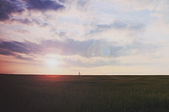 Sunrise Over Vast Grassland With Distant Structure