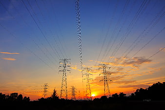 Silhouetted Power Lines Against Vibrant Sunset Sky