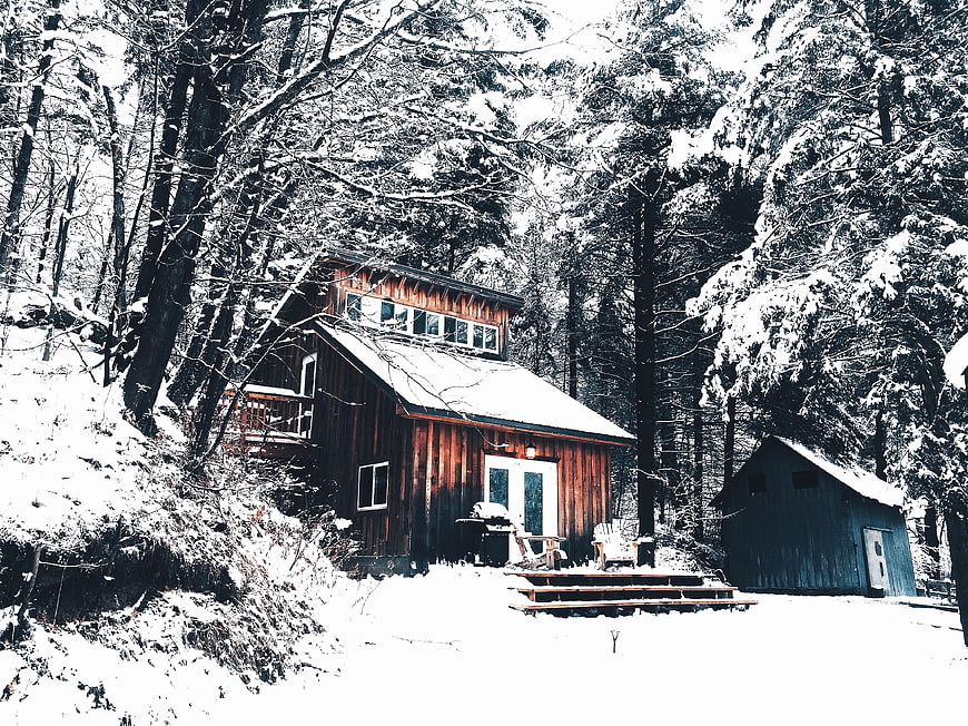 Rustic wooden cabin in snowy winter forest
