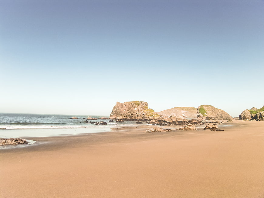 Sandy Beach with Rocky Outcrops and Blue Sky