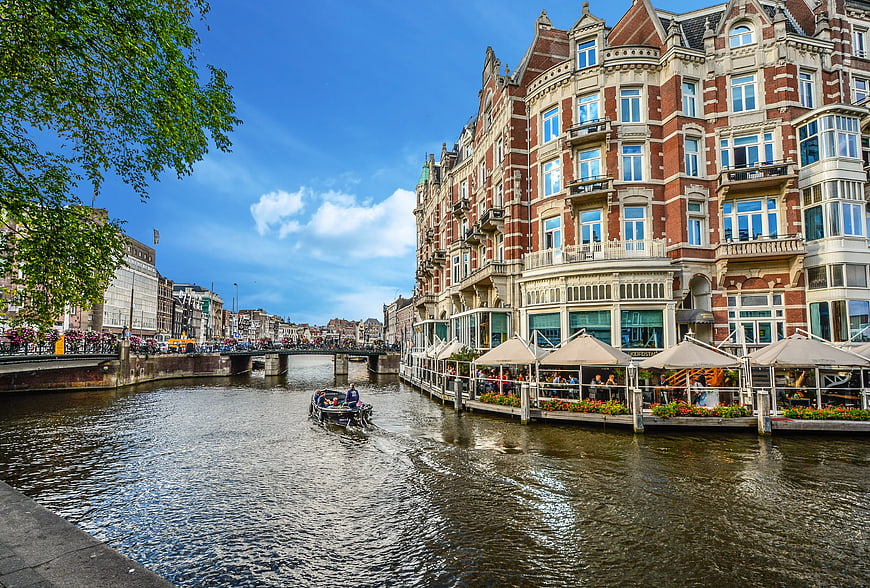 Amsterdam Canal Scene With Historic Architecture And Boat