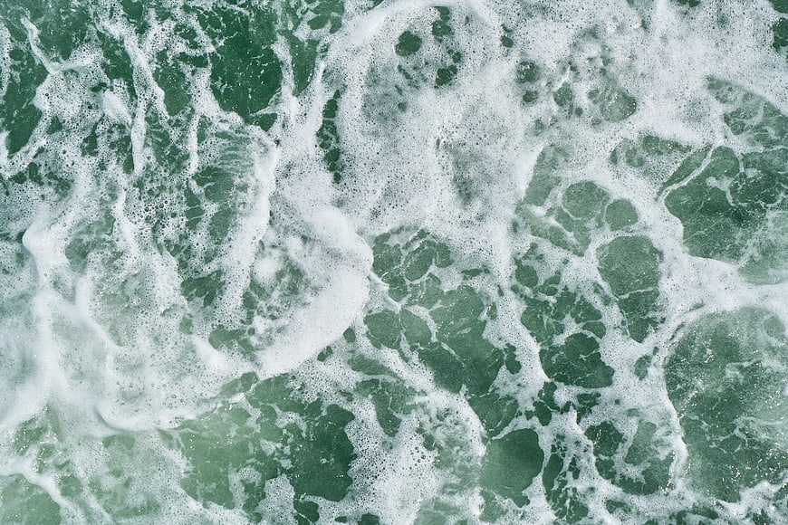 Aerial View of Green Ocean Waves and White Sea Foam