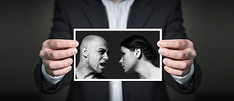 Businessman holding photo of arguing couple in black and white