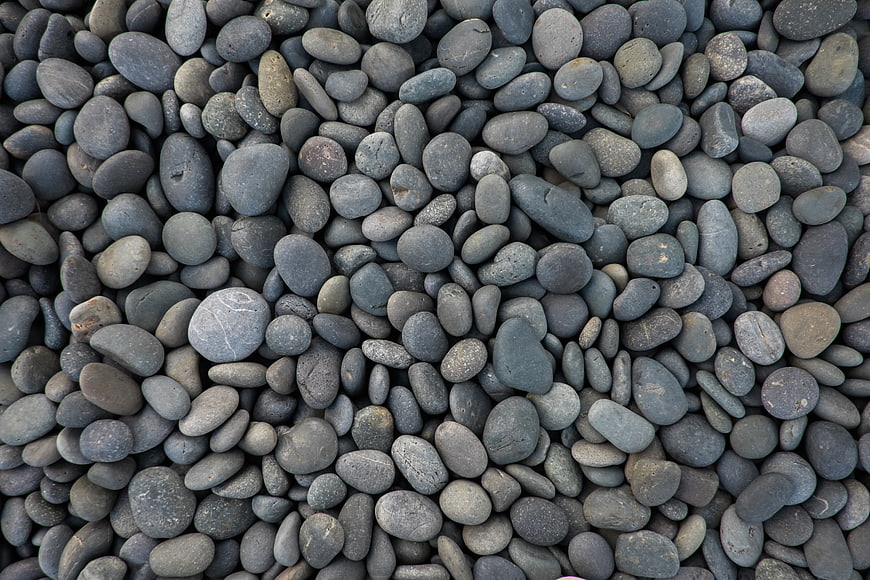 Close-up texture of smooth gray river pebbles and stones
