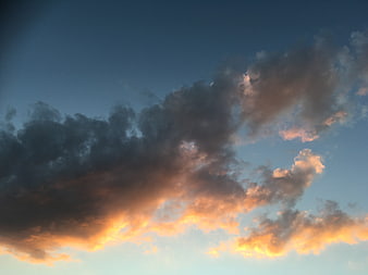 Dramatic sunset clouds with golden light against blue sky