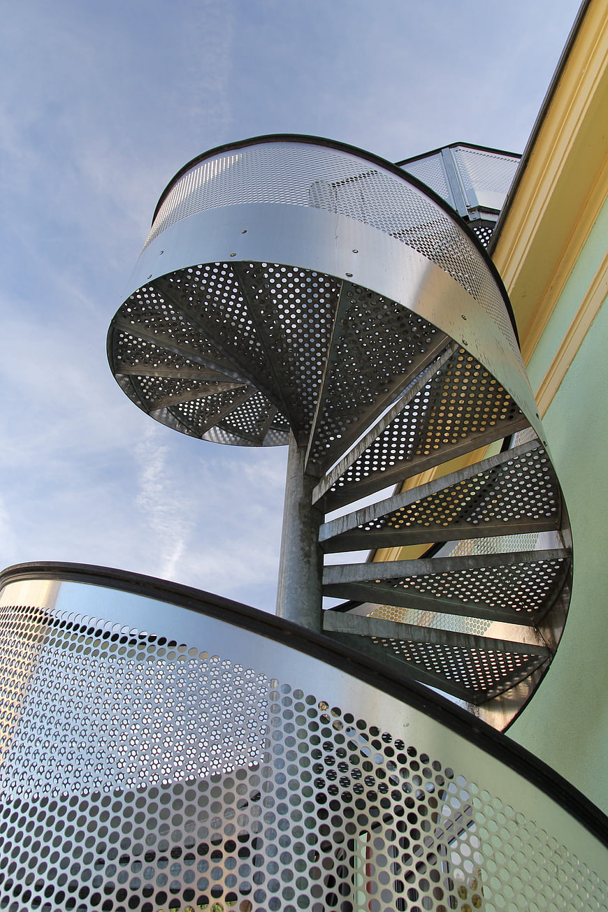Low angle view of modern perforated metal spiral staircase