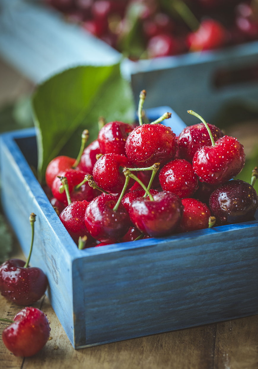 Fresh Red Cherries in Blue Wooden Crate with Water Droplets