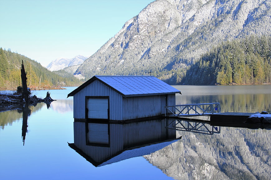 Boathouse on a Lake with Mountain Reflections