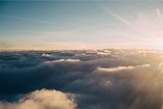 Aerial View of Golden Sunlight Over Sea of Clouds