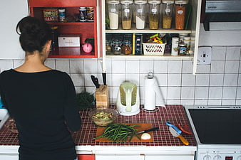 Woman cooking vegetables in a vintage kitchen interior