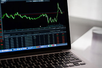Laptop Displaying Financial Candlestick Chart and Trading Data