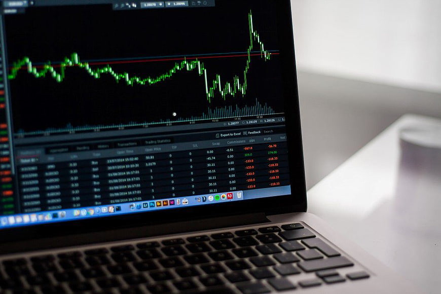Laptop Displaying Financial Candlestick Chart and Trading Data