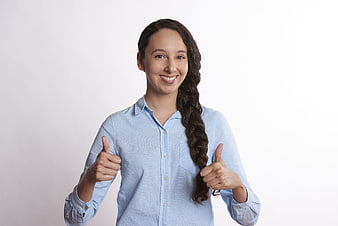 Smiling woman with long braid giving double thumbs up