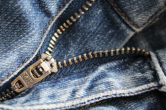 Close-up of brass zipper on blue denim jeans texture