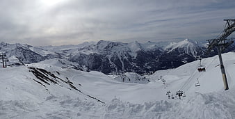 Panoramic View of Snowy Mountain Ski Resort with Chairlift