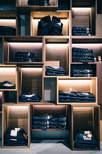 Neatly Folded Denim Jeans Displayed in Modern Wooden Retail Shelving