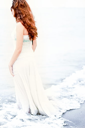 Woman in White Dress Standing in Ocean Waves