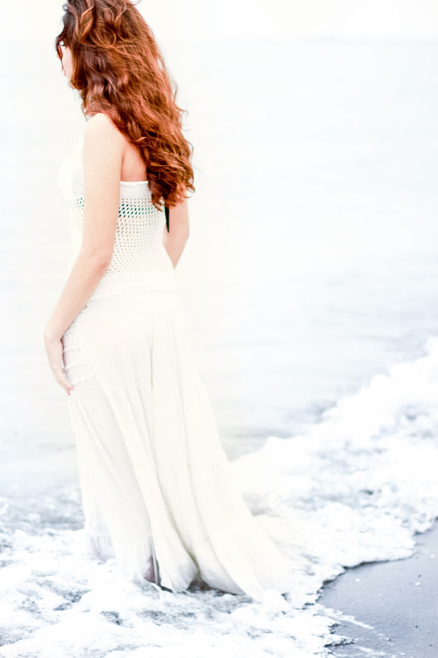 Woman in White Dress Standing in Ocean Waves