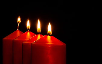 Four Lit Red Advent Candles on Black Background