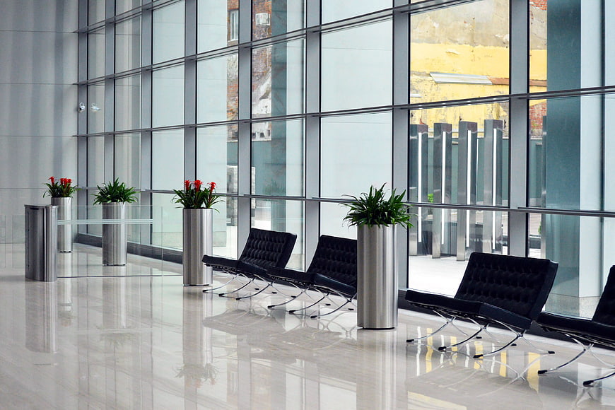 Modern corporate lobby with black leather chairs and glass windows