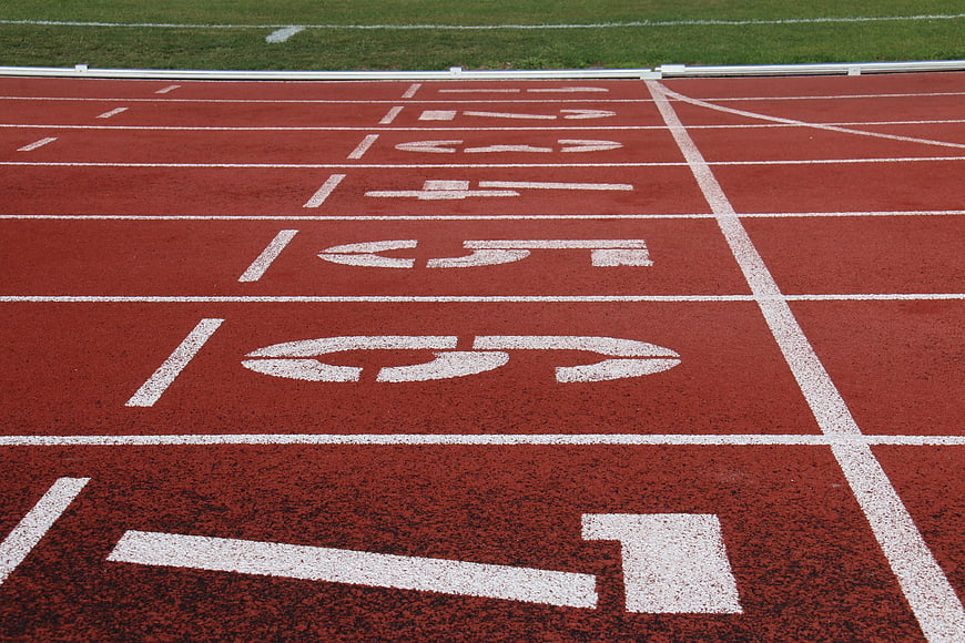 Red Running Track With White Lane Numbers And Finish Line