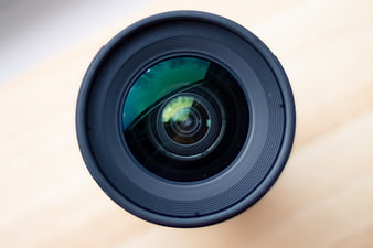Close-up of camera lens on wooden surface