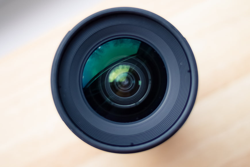 Close-up of camera lens on wooden surface