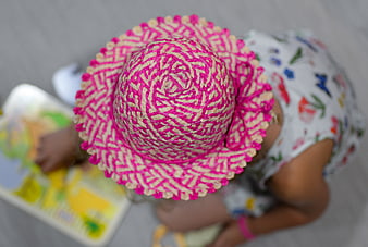 Top View of Little Girl in Pink Straw Hat Playing