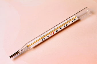 Glass Mercury Thermometer on Soft Pink Background