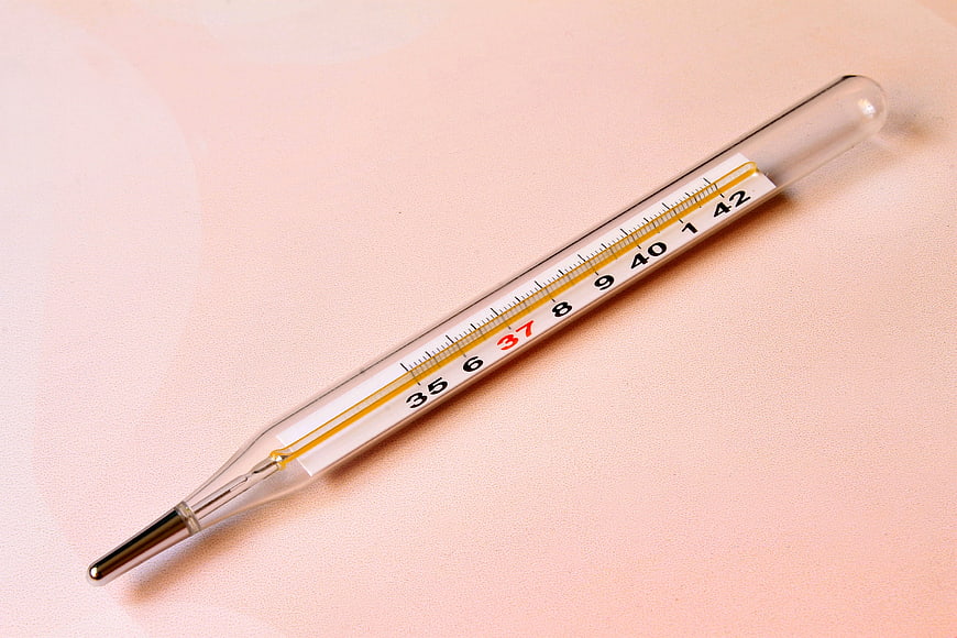 Glass Mercury Thermometer on Soft Pink Background