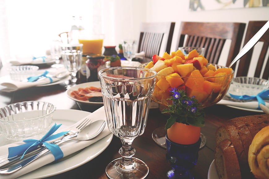 Elegant breakfast table setting with fruit salad and bread