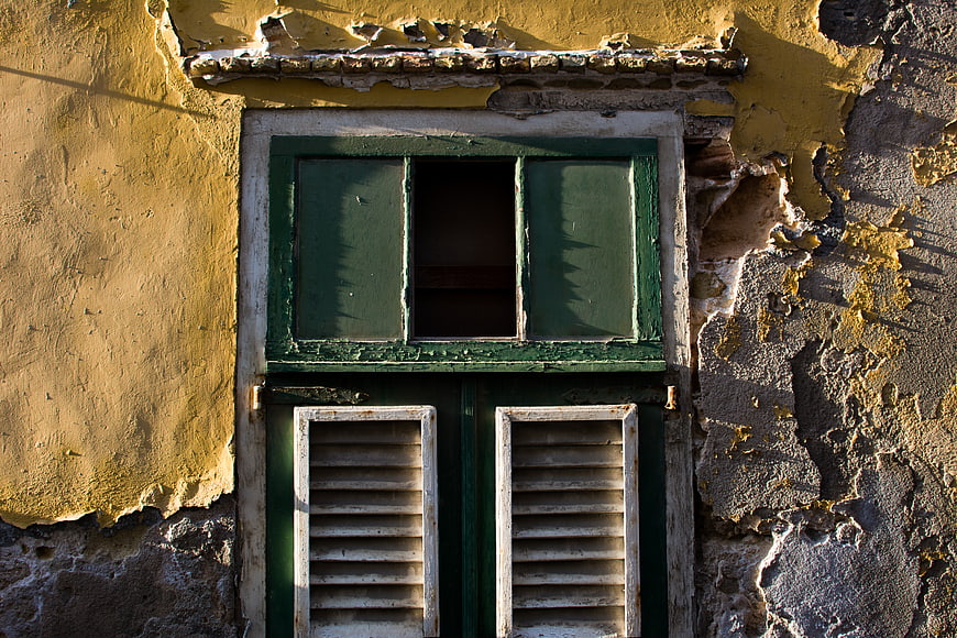 Weathered Green Window on Peeling Yellow Wall