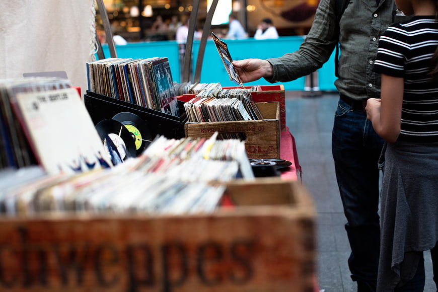 Couple browsing vinyl records at outdoor market stall