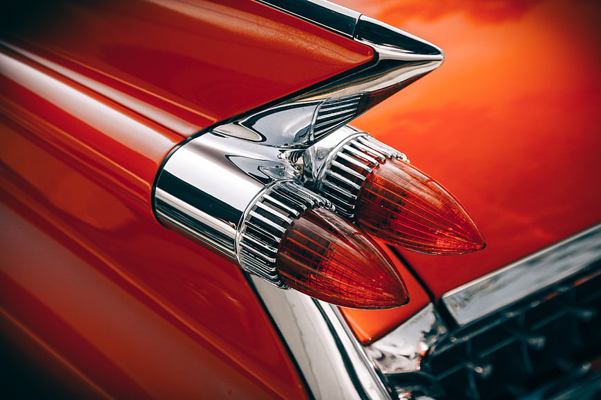 Close-up of vintage red car tail fin with chrome details