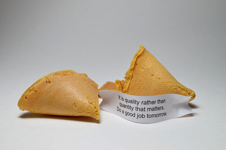 Broken fortune cookie with inspirational message on white background