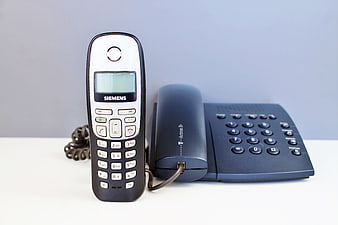 Siemens Cordless Phone and T-Actron Base Station on White Surface