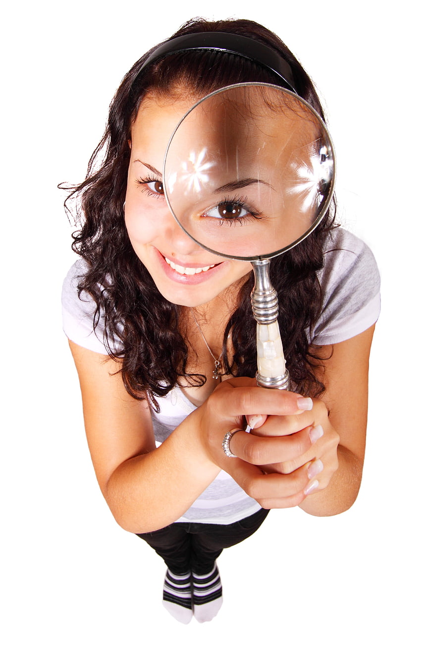 Young Woman Looking Through Magnifying Glass Isolated on White