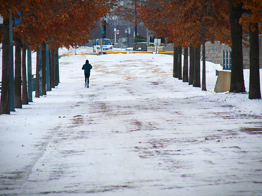 Lone Runner Jogging on Snowy Winter Path