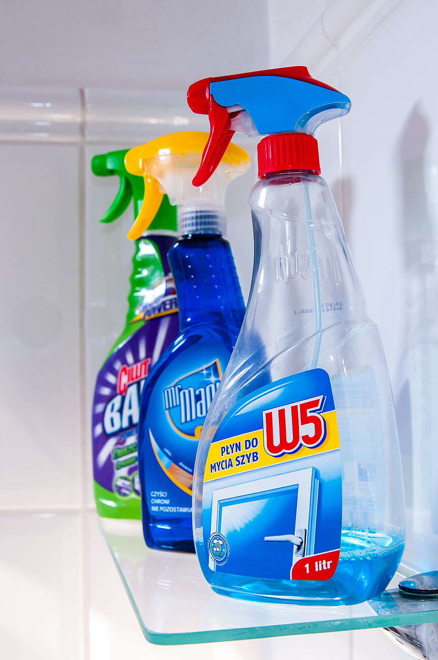 Colorful Cleaning Spray Bottles on Bathroom Shelf