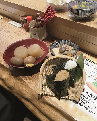 Traditional Japanese onigiri and simmered side dishes on wooden counter