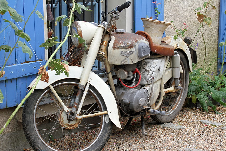 Vintage Rusty Motorcycle Parked in Garden