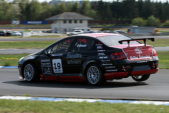 Black and red race car speeding on a racetrack