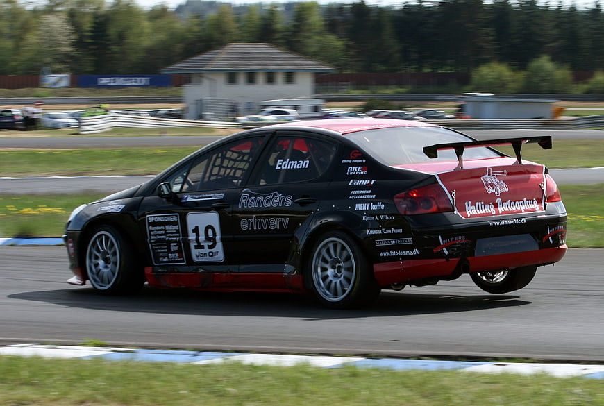 Black and red race car speeding on a racetrack