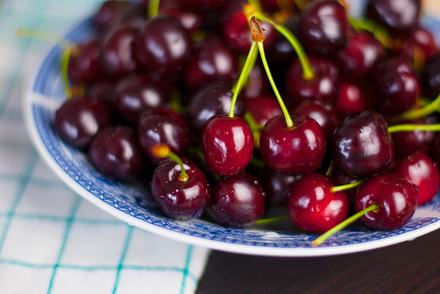 Fresh Red Cherries in Blue and White Ceramic Bowl