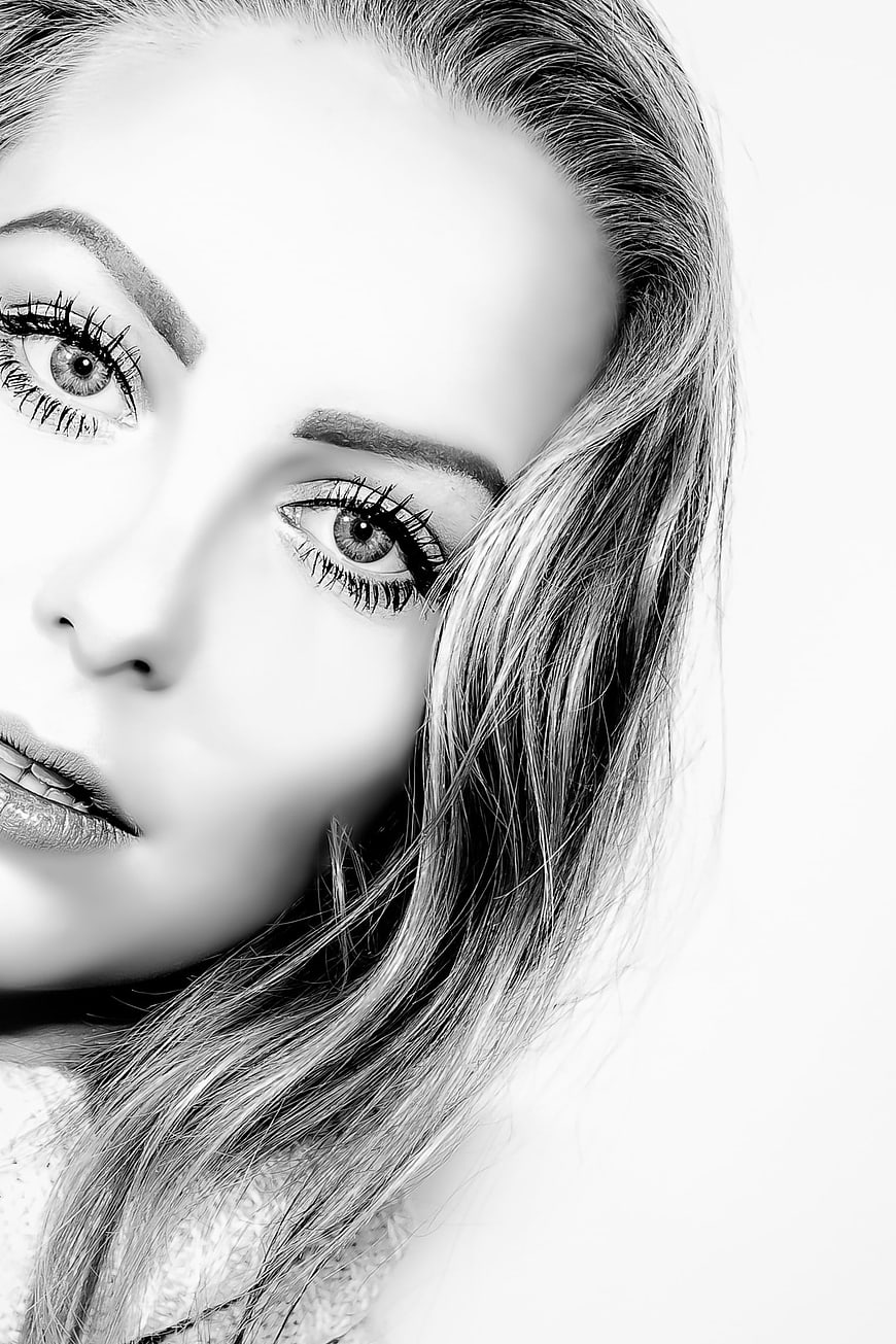 Black and white close-up portrait of a young woman with detailed eyes