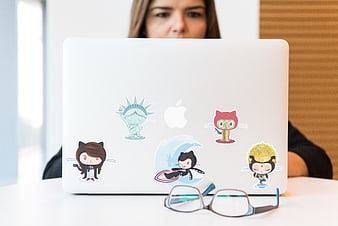 Woman working on laptop with stickers and glasses