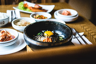 Traditional Korean Bibimbap with Egg Yolk and Side Dishes
